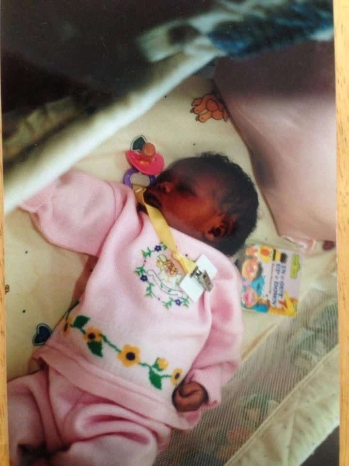 Newborn resting in a pink outfit
